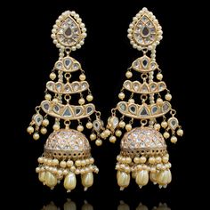 Preserve timeless charm into marvelous ensembles! With an absolute tale of elegance and sophistication, this pair showcases the beautiful composition of thapa kundan and beaded work with contemporary decorative pearl moti details adorned with true craftsmanship. Approximate earrings length is 4.5". Gold-plated on a high-quality brass as base metal. Made by order. Kindly allow 4-6 weeks for the delivery of this item. For custom or urgent requests, please contact support@alacouture.com. *Please No