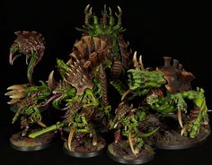 the warhammers are painted with green and brown paint on their heads, while they stand next to each other