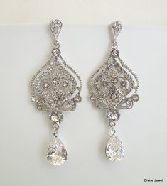 "These glamorous stud earrings have silver pendants with clear rhinestones and premium Austrian teardrop crystals. Earrings are approximately 3\" long. Crystal teardrop measures 14 x 10mm. Each pendant measures 1 3/4\" by 1\" wide. Elegant earrings for any glamorous bride! Coordinating necklace, https://www.etsy.com/listing/161923742/pearl-necklacebridal-rhinestone?ref=shop_home_active Other earrings styles, https://www.etsy.com/listing/161922066/bridal-wedding-earringschandelier?ref=shop_home_a Elegant Rhinestone Teardrop Chandelier Earrings, Elegant Teardrop Chandelier Earrings With Rhinestones, Silver Sparkling Dangle Teardrop Earrings, Sparkling Silver Dangle Teardrop Earrings, Silver Crystal Drop Bridal Earrings, Silver Pear-shaped Chandelier Earrings For Party, Teardrop Crystal Chandelier Earrings For Pierced Ears, Teardrop Crystal Chandelier Earrings, Teardrop Crown Jewelry With Rhinestones For Wedding