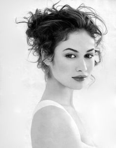 a black and white photo of a woman with curly hair