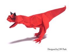 a red origami dragon is on the white background and looks like it's made out of paper