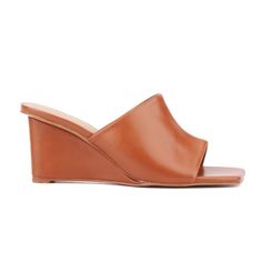 Whether you're heading out for a night on the town or enjoying brunch with friends, the Candie has you covered. This open-toe mule features a chic wedge that combines style with comfort, making it perfect for all-day wear. The versatile design effortlessly complements any outfit, ensuring you look fashionable from day to night. With its blend of elegance and practicality, the Candie is a must-have addition to your wardrobe, offering both sophistication and ease for any occasion. Chic Summer Wedge Sandals With Stacked Heel, Brown Slide Mules For Spring, Brown Spring Formal Mules, Brown Formal Mules For Spring, Formal Brown Mules For Spring, Brown Slide Wedge Sandals For Spring, Summer Wedge Mules With Padded Heel, Summer Slip-on Mules With Padded Heel, Summer Mules With Padded Wedge Heel