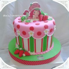 a pink and green cake with strawberrys on top