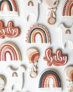 some cookies that are shaped like rainbows and the words baby spelled in cursive letters