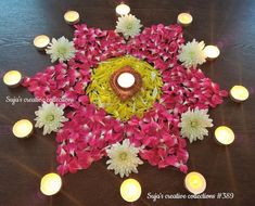 an arrangement of flowers and lit candles on a table with the words happy diwaling celebrations written below