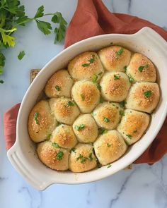 a casserole dish filled with rolls and garnished with parsley