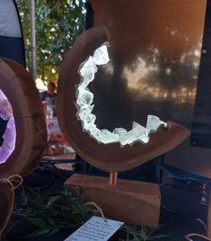 a wooden sculpture with white frost on it's face in front of other wood sculptures