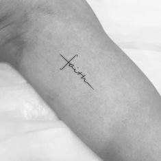 a person's arm with the word faith on it and a cross in the middle