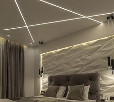 a modern bedroom with white walls and grey bedding, lights on the headboard