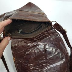 "Possibly handmade artisan leather bag with camel detail. 8 1/2\" across 10\" long 19\" strap Outer pocket * Please review all shop policies before completing transaction. All sales final. No returns/exchanges. * Bundle up - we combine shipping. * Instagram @vintagerunsdeepshop" Brown Saddle Bag With Leather Lining And Flap, Brown Leather Saddle Bag With Flap And Leather Lining, Brown Artisan Saddle Shoulder Bag, Camel Leather Lined Satchel Shoulder Bag, Camel Leather-lined Satchel Shoulder Bag, Artisan Travel Shoulder Bag With Leather Lining, Artisan Shoulder Bag With Leather Lining For Travel, Travel Brown Saddle Bag With Leather Backing, Artisan Shoulder Bag For Travel With Leather Lining