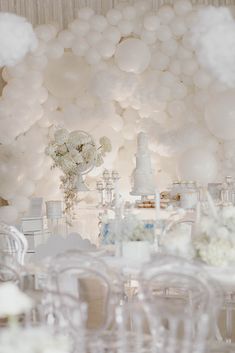 a table topped with lots of white balloons