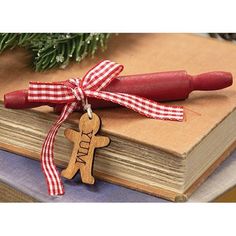 an ornament on top of a book with a red ribbon and a wooden cross