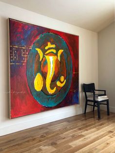 an abstract painting hangs on the wall next to a chair