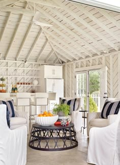 a living room filled with white furniture and lots of pillows on top of it's covers