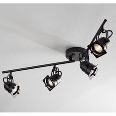 three spotlights are hanging from the ceiling in a room with white walls and black fixtures