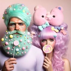 two people with pastel hair and pink wigs are holding lollipops