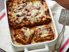 lasagna casserole with meat and cheese in a white dish on a towel