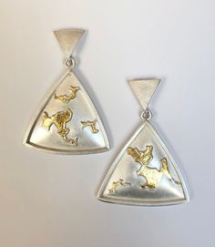 Gold & Silver Earrings - Bedazzle in these unique drop earrings. Hydraulically-pressed fine silver triangles are hand appliqued with differing shapes of sterling and fine silver, then accented with 23k gold keum bu.  Secured with silicone lined sterling silver bullet clutches. Artistic Jewelry Handmade, Unique Silver Earrings With Polished Finish, Unique Triangle Sterling Silver Jewelry, Sterling Silver Triangle Earrings For Pierced Ears, Nickel-free Triangle Sterling Silver Jewelry, Polished Sterling Silver Earrings, Sterling Silver Triangle Jewelry With Matching Earrings, Handmade Triangle Sterling Silver Jewelry, Handmade Sterling Silver Triangle Jewelry