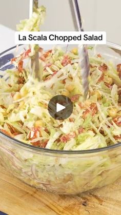 a salad being prepared in a glass bowl on top of a wooden cutting board with the words la scata chopped salad