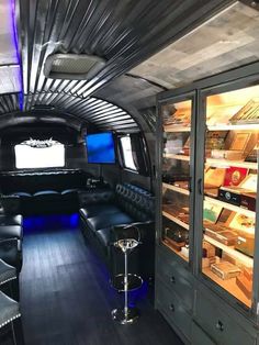 the interior of an airplane with black leather furniture and blue lights on it's windows