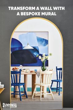 a dining room with blue chairs and a painting on the wall that says transform a wall with a bespoke mural