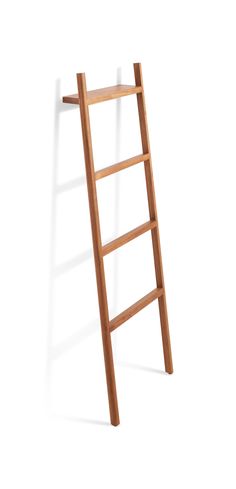 a wooden ladder leaning up against a white wall