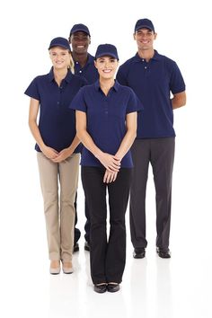 four people in blue shirts and khakis are posing for the camera on a white background