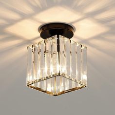 a square light fixture with clear crystal cubes hanging from it's center point