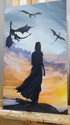 a painting of a woman standing on a hill with bats flying over her and the sun setting in the background