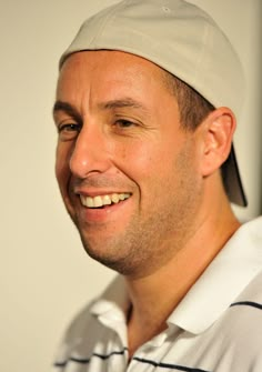 a man wearing a white hat smiling for the camera