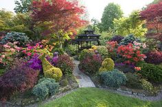 the garden is full of colorful flowers and trees, with a gazebo in the middle