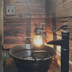 an old frying pan is sitting on a table next to a lamp and wood paneled wall