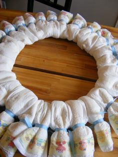 a wreath made out of diapers sitting on top of a wooden table