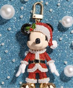 a mickey mouse keychain with a santa clause outfit on it's head