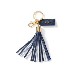 a blue and white tasseled keychain hanging from a gold - toned metal hook