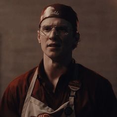 a man wearing glasses and an apron