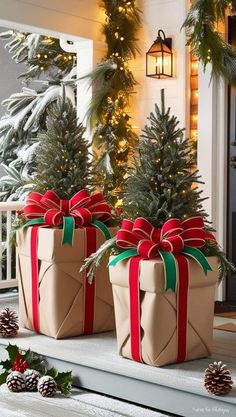 two wrapped presents sitting on the porch with christmas decorations around them and pine cones in front