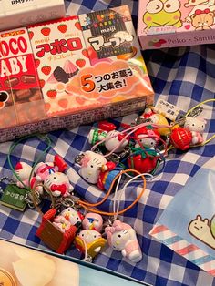 many hello kitty keychains are laying on a blue and white checkered blanket