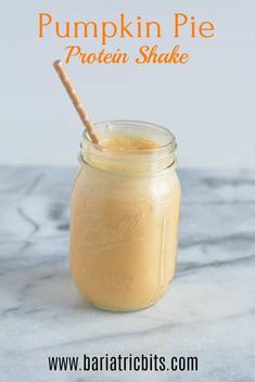 a glass jar filled with liquid sitting on top of a marble counter next to a wooden straw