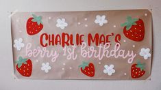 a sign that says charlie mac's berry 1st birthday with strawberries on it