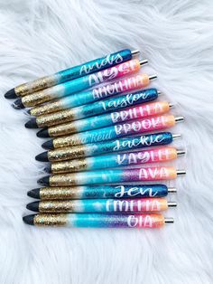 six pens with glitter on them are lined up in a row