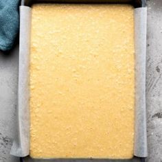 a pan filled with batter sitting on top of a counter next to a blue towel