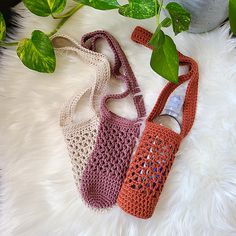 two crocheted purses sitting next to each other on a white furnishing