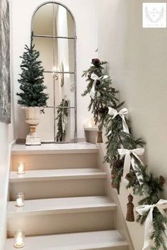 christmas decorations on the stairs in front of a mirror