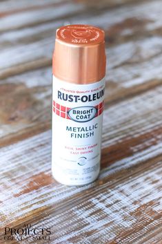 a rust - oleium spray can sitting on top of a wooden table