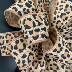 a leopard print bow hanging on the side of a door with black and tan trim