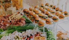 an assortment of food on display at a buffet or wedding reception, including burgers and salads