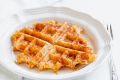 a white plate topped with waffles on top of a table