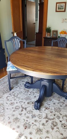 a dining room table with blue chairs and a white rug on the floor in front of it