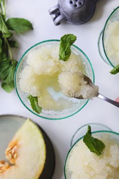 three glasses filled with ice cream and mint garnish on top of a table